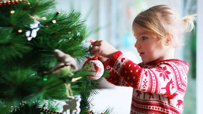 girl_decorating_christmas_tree_AdobeStock_93832211_copyright_cromary_1100x620px_221215
